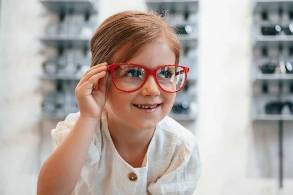 Little girl in the glasses store selecting a new eye wear